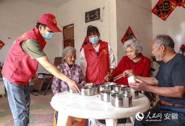 陈红旗（左）和同事将打包好的饭菜送到一些失能、独居、高龄的老年人家里。