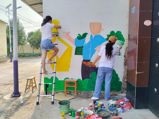 河北省东光县烟草局志愿者正在绘制文化墙。 赵越摄