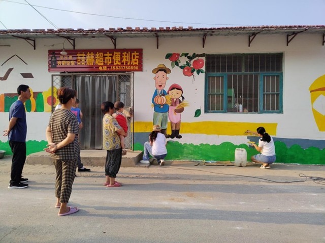 河北省东光县烟草局志愿者正在绘制文化墙。 赵越摄