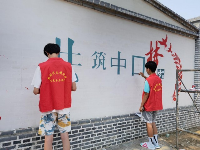 返乡大学生志愿者正在绘制文化墙。 赵越摄