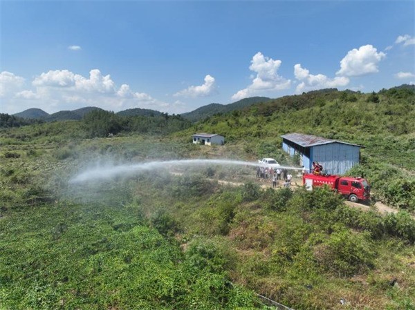 志愿者们利用水利设施设备引水灌溉农田。单位供图