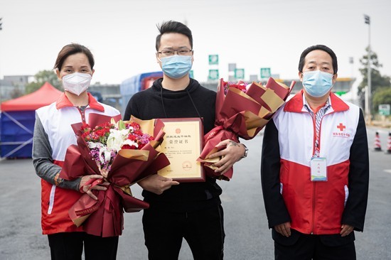 邵东市红十字会工作人员将两束鲜花送给逆行长沙捐献造血干细胞返回邵东的志愿者。受访单位供图
