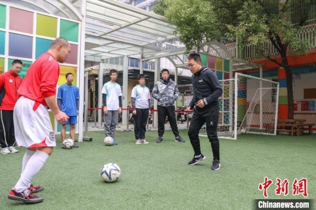 图为球队教练(右1黑色外衣)和一名队员在给其他队员示范传接球的标准动作。　刘力鑫 摄