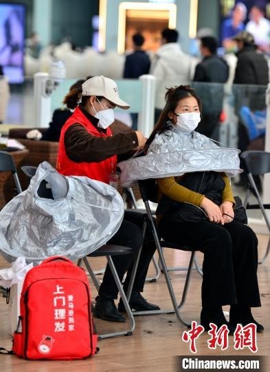 1月17日，参加服务活动的志愿者在福州火车站候车厅为旅客进行理发。　张斌 摄