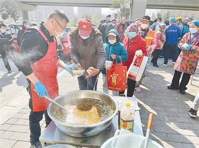 “郑州八哥”公益团体为农民工提供免费午餐
