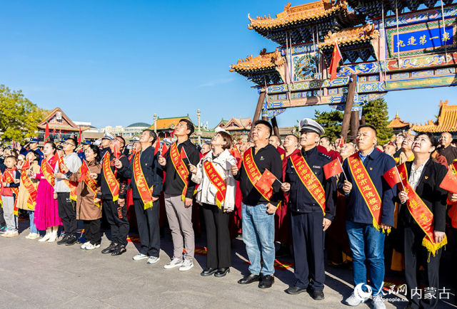 10月1日，道德模范、新时代好少年和最美志愿者等代表在呼和浩特市玉泉区塞上老街文化旅游休闲街区参加国庆节升旗仪式。丁根厚摄