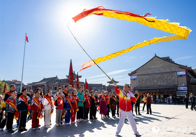 10月1日，道德模范、新时代好少年和最美志愿者等代表在呼和浩特市玉泉区塞上老街文化旅游休闲街区观看舞龙表演。丁根厚摄