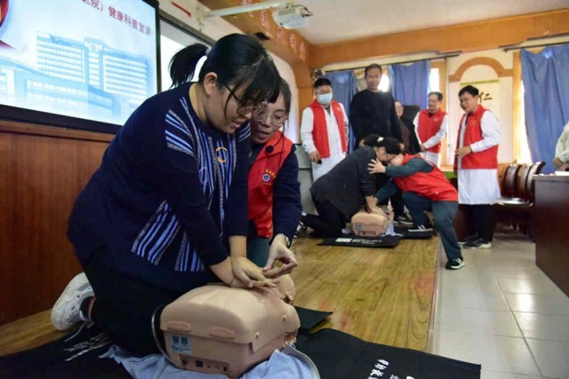 医疗志愿者指导教师练习心肺复苏术。 尹向平摄