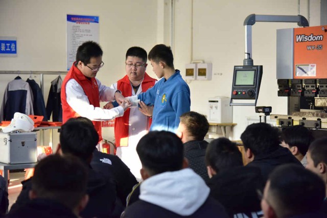 青县医疗志愿者在数控机床实操教室向学生传授急救技巧。 尹向平摄