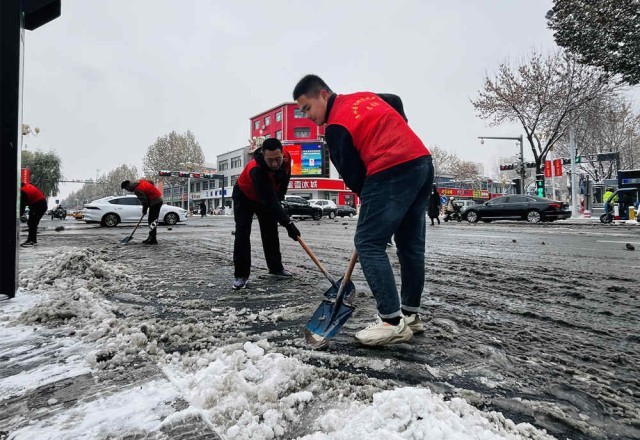 志愿者清理非机动车道上的积雪。 李金璐摄