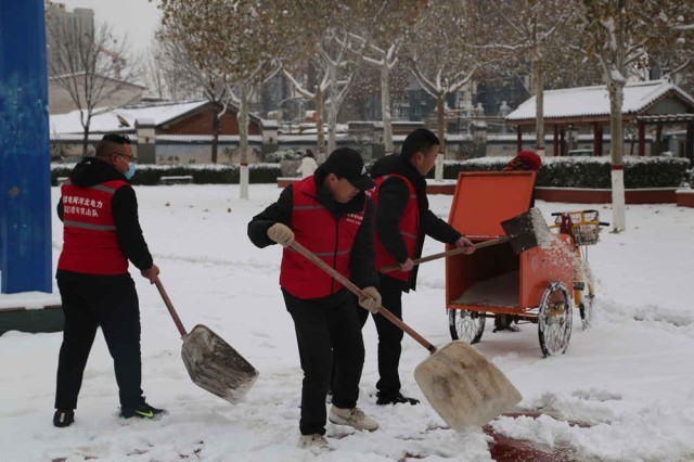 志愿者协助环卫工人撒融雪剂。 李金璐摄