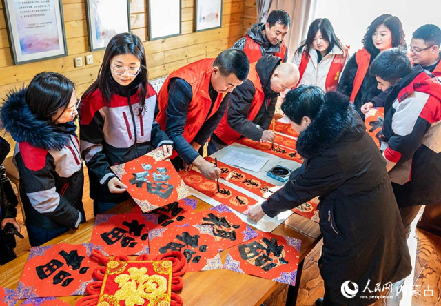 志愿者在呼和浩特市玉泉区总工会劳动者港湾为外卖配送、快递物流、网约车等工作者书写春联和中国“福”。丁根厚摄