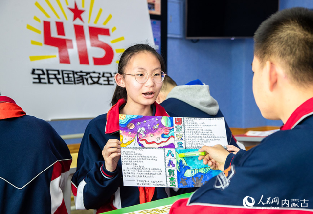 4月12日，内蒙古呼和浩特市第二十六中学学生在展示绘制的国家安全教育主题手抄报。丁根厚摄