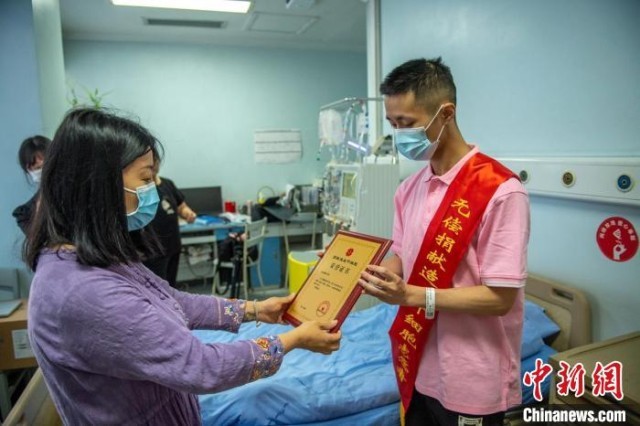 工作人员为大学生王浩臻颁发造血干细胞捐献证书等。　刘忠俊 摄