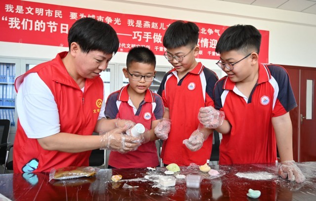 同学们在志愿者的帮助下制作手工月饼。 刘蒙蒙摄