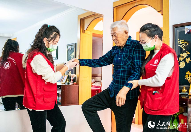 玉泉区民政局的党员志愿者上门为社区老人李国材提供肢体康复训练服务